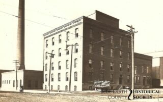 Hubbard Mill circa 1900, black and white image with a building and a cart